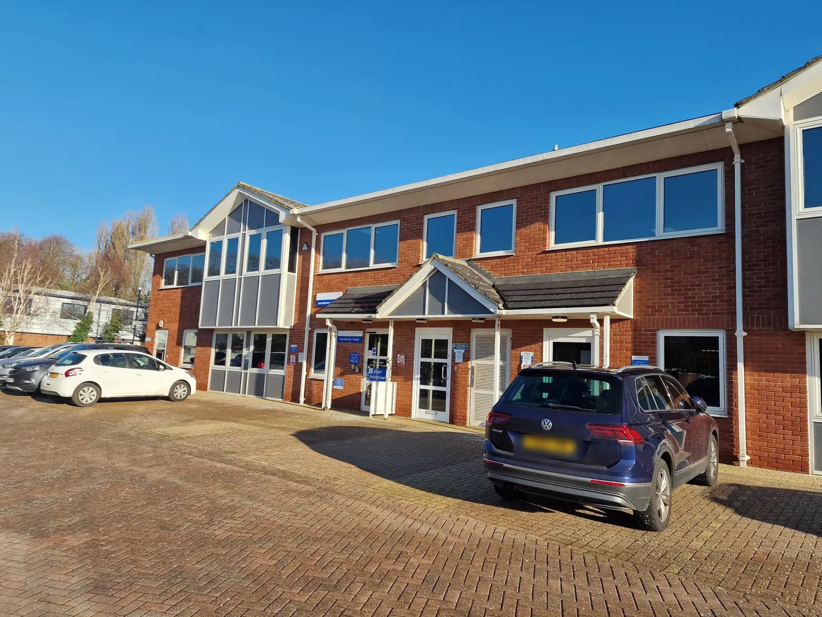 Two-storey red-brick office building with a gabled entrance porch and block-paved car park at Aerodrome House, Frater Gate Business Park, Gosport
